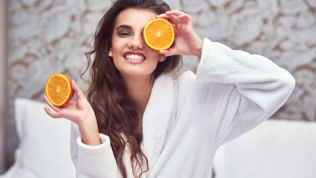 תמונה של אישה מחזיקה בתפוזים
