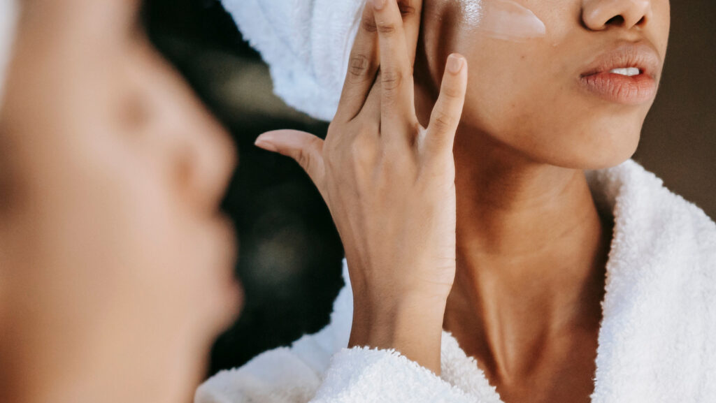 תמונה של אישה מורחת קרם פנים לעור שמן